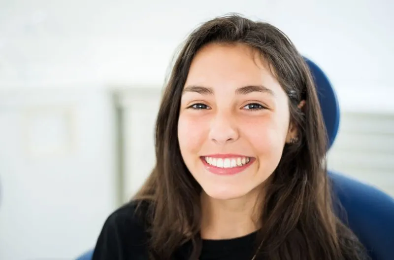 Smiling young woman in a dental chair, representing a positive experience at Lakeside Oral Surgery